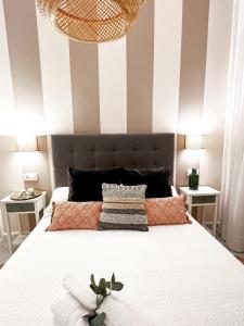 塞维利亚Spalis Suite Loft de lujo en el centro histórico的一间卧室设有一张带条纹墙的大床