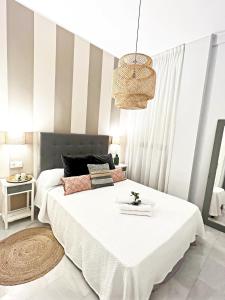 塞维利亚Spalis Suite Loft de lujo en el centro histórico的卧室配有一张白色大床和条纹墙