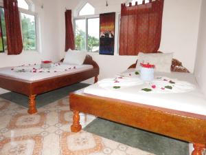 江比阿Mudi House的两张床位于带鲜花的房间