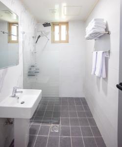 西归浦市济州阿鲁姆顿度假村的白色的浴室设有水槽和淋浴。