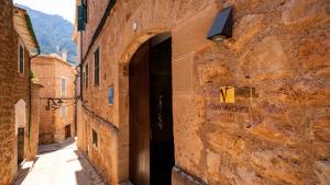 福纳卢奇Hotel Can Verdera的一条有门的老石头建筑的小巷