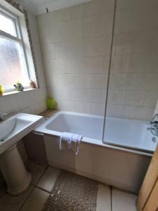 温莎Inviting 2-Bed Cottage in Windsor的白色的浴室设有浴缸和水槽。