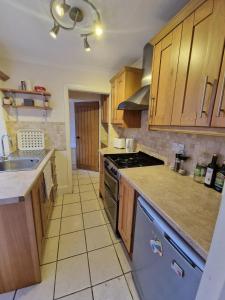 温莎Inviting 2-Bed Cottage in Windsor的厨房配有木制橱柜和炉灶烤箱。