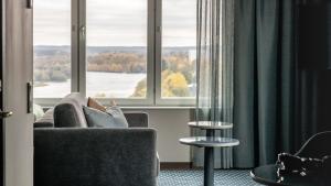 于默奥Clarion Hotel Umeå的坐在沙发上,从窗户望出去的人