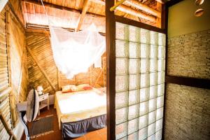 拉特里尼泰Shuit Bambou的一间卧室配有一张床和蚊帐