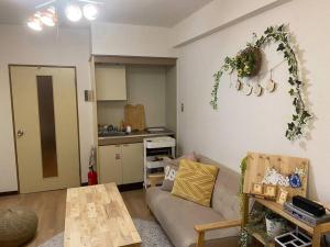 东京副都心線池袋駅から徒歩2分のマンション的带沙发和桌子的客厅以及厨房。