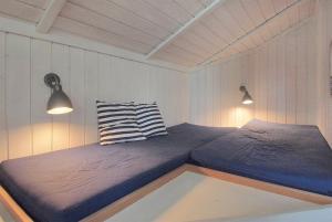 博托比Sommerhus i Marielyst m/Spa og sauna - tæt på by og strand的带2盏灯的客房内的2张单人床