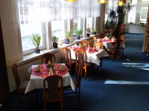 埃伦德瓦尔德木和勒酒店的用餐室设有桌椅和窗户。