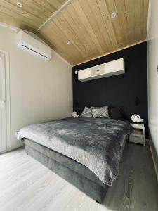 TraisenVoralpen Lodge - Ferienhaus mit Gym, Sauna & Hot Tub的一间卧室设有一张大床和黑色墙壁