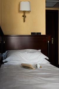 罗卡拉索小百合酒店的一张带书、杯子和书的床