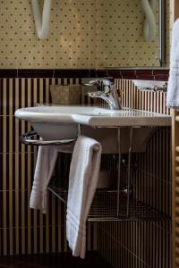 罗卡拉索小百合酒店的一间带水槽和架子毛巾的浴室