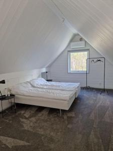 维斯比Fräscht, spatiöst hus的白色的卧室设有床和窗户