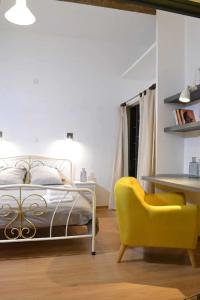 蒙彼利埃Apprt Top Center / 2 Chambres / 2 Salles de bain.的一间卧室配有一张床和一张黄色椅子