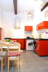 蒙彼利埃Apprt Top Center / 2 Chambres / 2 Salles de bain.的厨房配有红色橱柜和桌椅