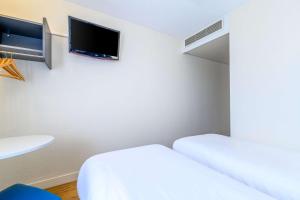 塞纳河畔伊夫里基里亚德巴黎波特伊芙酒店的客房设有两张床和一台平面电视。