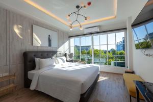 清迈R2 Hotel Chiangmai的一间卧室设有一张大床和一个大窗户