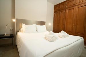 戈梅拉岛圣塞瓦斯蒂安Holiday House Penthouse in La Gomera的卧室配有带毛巾的大型白色床