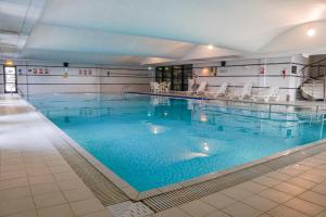 利物浦皇冠假日利物浦市中心酒店的一座带蓝色水和白色椅子的大型游泳池