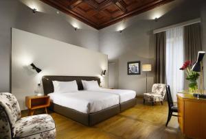佛罗伦萨Hotel Garibaldi Blu - WTB Hotels的配有一张床和一把椅子的酒店客房