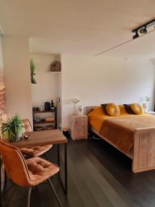SmildeDe Schotse Hooglander的一间卧室配有一张床、一张木桌和一张桌子。