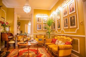 都柏林克尔洛南酒店的客厅配有黄色家具,墙上挂有图片