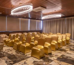 加尔各答Brio Hotel的一间设有金色椅子和舞台的会议室