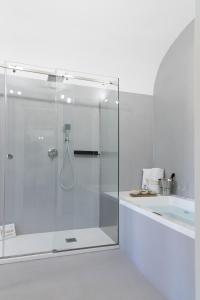 巴勒莫Peonia Boutique Apartments的带浴缸的浴室内的玻璃淋浴间