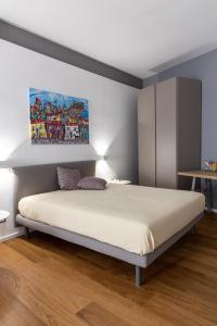 巴勒莫Peonia Boutique Apartments的卧室配有一张床,墙上挂有绘画作品