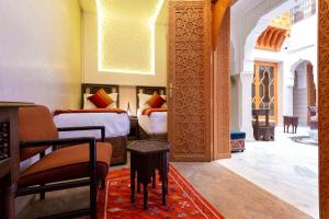 马拉喀什Palais Tara & Spa的一间卧室配有两张床和一张桌子。