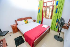 波隆纳鲁沃Heritage villa polonnaruwa的一间卧室配有一张带风扇和窗户的床。