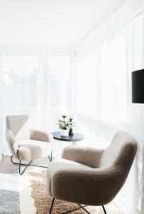 苏黎世Lamira - Serviced Apartments的客厅配有两把椅子和一张桌子