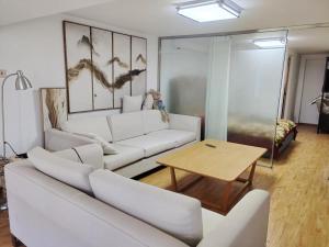 北京Chaoyang Joy City Hardcover Apartment的客厅配有白色的沙发和桌子
