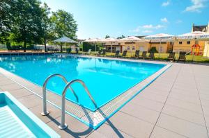 雷德尼斯雷德尼斯戈蓝酒店的一座大型游泳池,设有通往游泳池的金属楼梯