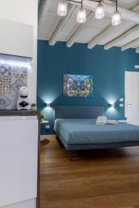 巴勒莫Peonia Boutique Apartments的蓝色的卧室,配有床和蓝色的墙壁