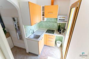 帕劳Vento Mare Apartments的小厨房配有橙色橱柜和水槽