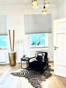慕尼黑Puro-Design-Apartment Deluxe - very central的客厅配有斑马地毯和椅子