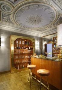 佛罗伦萨Hotel Garibaldi Blu - WTB Hotels的一间酒吧,里面设有2张凳子,房间设有天花板