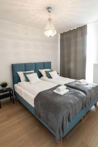 克拉科夫Sołtysowska Apartment的一间卧室配有一张大床和蓝色床头板