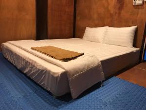 Xuan DamBee lucky homestay cat ba Island的一张铺有白色床单的床和一张棕色的毯子