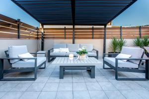 略夫雷加特河畔奥斯皮塔莱特Barcelona Touch Apartments的庭院配有两把椅子、一张桌子和一张沙发