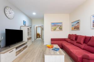 圭马尔港Home2Book Charming Apartment Puertito de Güímar的客厅配有红色沙发和电视