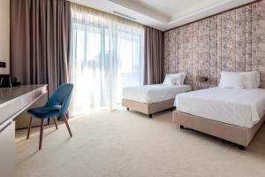 蒂米什瓦拉Hotel Stein Collection的酒店客房,设有两张床和一张蓝色椅子