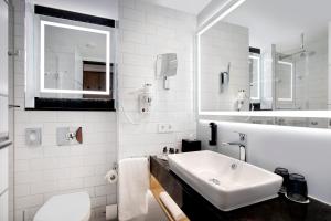 奥斯纳布吕克Holiday Inn - Osnabrück, an IHG Hotel的白色的浴室设有水槽和镜子