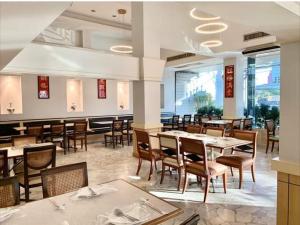 曼谷珍宝多酒店 的餐厅内带桌椅的用餐室