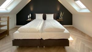 托伦Waterrijk Oesterdam Resort Villas的卧室配有一张带白色床单和枕头的大床。