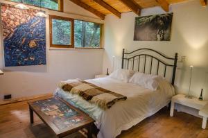 圣卡洛斯-德巴里洛切la casa del sol的卧室配有一张床,墙上挂有绘画作品