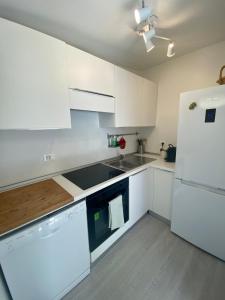 维亚雷焦FrontBeach Attic Apartment - with access to beach club的厨房配有白色橱柜和白色冰箱。