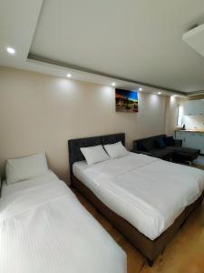 伊斯坦布尔BLUE ROYAL HOTEL的配有白色床单的客房内的两张床