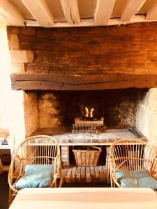 Maison de famille du 17ème siècle的一张桌子、三把椅子和壁炉