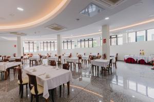 圣克鲁斯-德拉帕尔马加雷翁公寓酒店的一间设有白色桌椅和窗户的用餐室